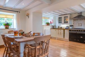 a kitchen with a wooden table and chairs in a room at Bryn Rhydd in Eglwys-Fâch +12 photos