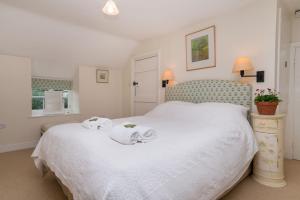a bedroom with a large white bed with towels on it at Bryn Rhydd in Eglwys-Fâch