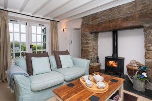 a living room with a couch and a fireplace at Bryn Rhydd in Eglwys-Fâch