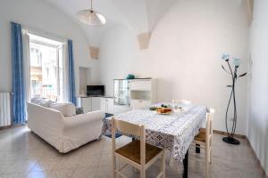 Un comedor blanco con una mesa y sillas. en Typical Apulian Apartment, en Martina Franca
