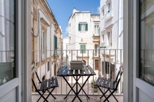 Un balcón con dos sillas y una mesa en un balcón. en Typical Apulian Apartment, en Martina Franca