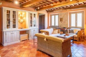 uma sala de estar com cadeiras de vime e uma mesa em Villa Fenice Country House em Borgo a Mozzano