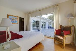 Schlafzimmer mit einem Bett und einer Glasschiebetür in der Unterkunft Villa du domaine au Pyla sur mer in La Teste-de-Buch