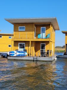 une maison sur un bateau sur l'eau dans l'établissement 4 Sterne Dtv Floating House, à Kröslin