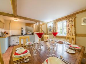un comedor con una mesa de madera con copas de vino en Bearwood Cottage en Pembridge