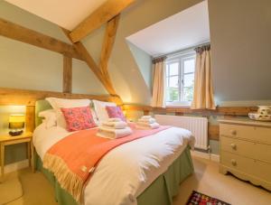 1 dormitorio con 1 cama con toallas en Bearwood Cottage en Pembridge