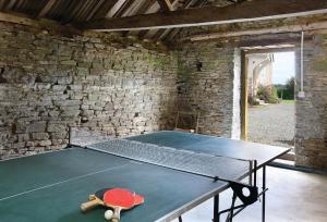 a ping pong table in a room with a stone wall at Upper Mowley in Kington