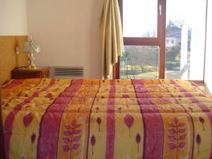 um quarto com uma cama com uma colcha colorida em Les Chalets Du Pres D'amont em Vagney