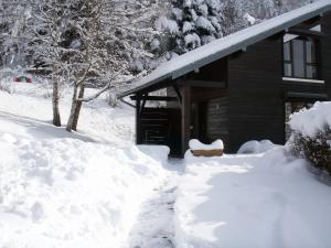 um monte de neve em frente a uma cabana em Les Chalets Du Pres D'amont em Vagney