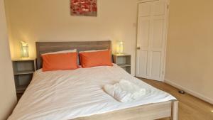 a bedroom with a bed with two orange pillows at Olive House in Manchester
