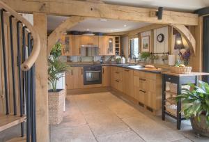 a kitchen with wooden cabinets and a wooden archway at Cherrystone Barn in Chalvington