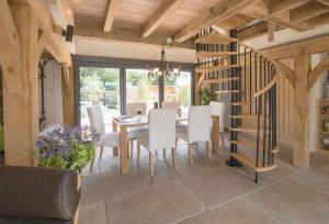 a dining room with a table and white chairs at Cherrystone Barn in Chalvington