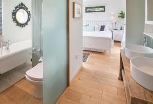 a bathroom with a toilet and a sink and a bed at Cherrystone Barn in Chalvington