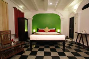 a bedroom with a bed with a green wall at Le Chateau in Puducherry