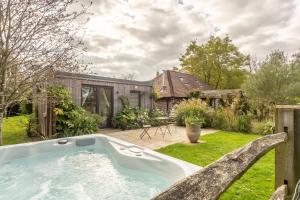 a hot tub in the yard of a house at Cherrystone Barn in Chalvington