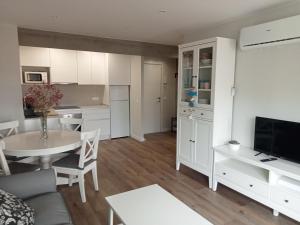 a living room with a table and a kitchen at SEAFRONT APARTMENT PINEDA BEACH in La Pineda +18 photos