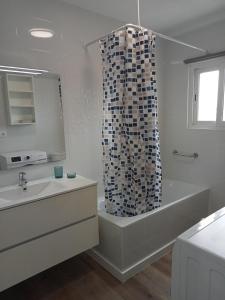 y baño con bañera y cortina de ducha. en SEAFRONT APARTMENT PINEDA BEACH, en La Pineda