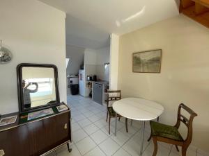 a dining room with a table and a mirror at A deux pas de la grande plage in Quiberon