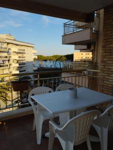 a white table and chairs on a balcony at SEAFRONT APARTMENT PINEDA BEACH in La Pineda