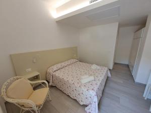a small bedroom with a bed and a chair at Le Roccette Mare Beach Hotel & Restaurant in Tropea