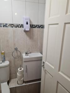 a bathroom with a toilet and a sink and a door at Lovely Property in London