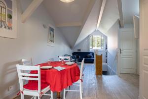 jadalnia z czerwonym stołem i krzesłami w obiekcie Appartement Le Moulleau w Arcachon