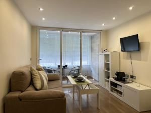 a living room with a couch and a tv at studio Monserrate F in Torrevieja