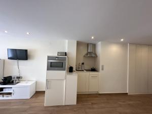 a kitchen with white cabinets and a refrigerator at studio Monserrate F in Torrevieja +2 photos