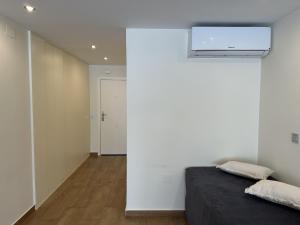 a bedroom with a white wall and a bed at studio Monserrate F in Torrevieja