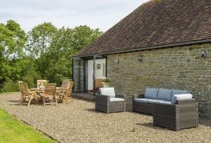 a patio with furniture and a table and chairs at Wassell Barn in Craven Arms