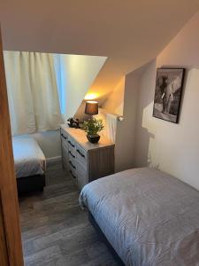a bedroom with two beds and a dresser with a lamp at Happy Home Eeklo in Centre in Eeklo