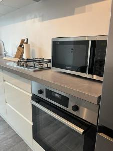 een keuken met een magnetron op een aanrecht bij Happy Home Eeklo in Centre in Eeklo