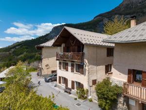 a building with a balcony and a car parked in a parking lot at Le Crampon in Les Orres