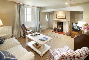 a living room with a couch and a fireplace at Librarian's Cottage in Coneysthorpe