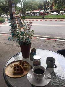 une table avec des gaufres et deux tasses de café dans l'établissement 4Beds#Aircon#Mixeddorm#@Oldcity, à Chiang Mai