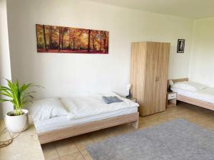 a bedroom with two beds and a painting on the wall at Schickes Apartment in Offenbach am Main in Im Teller