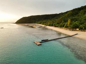 a boat in the water next to a beach at Cruiser Island By Swiss-Belhotel in Ko Lone