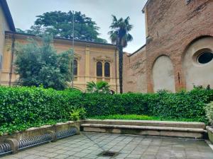 a building with a hedge and a sidewalk in front at Ca' Spadoni, centro storico, piano terra, ingresso indipendente, teatro, parcheggio, in Imola +43 photos