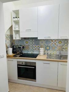 uma cozinha com armários brancos e um forno com placa de fogão em LA CASINA SULL'ARNO em Florença