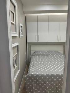 um pequeno quarto com uma cama e armários brancos em LA CASINA SULL'ARNO em Florença