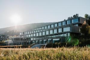 a large building with glass windows in a field at Hôtel des Horlogers in Le Brassus