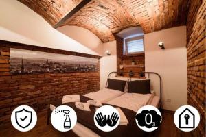 a bedroom with two beds and a brick wall at Cracow Rent Apartments - spacious apartments for 2-7 people in quiet area - Kolberga Street nr 3 - 10 min to Main Square by foot in Krakow