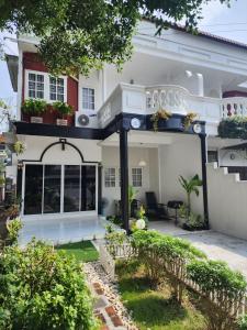 a white house with a balcony and a yard at Boxsoon Nimman 2 in Chiang Mai