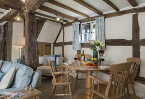 a living room with a table and a blue couch at Cobbler's Cottage in Pembridge