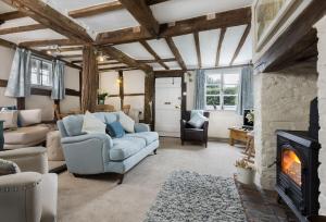 a living room with a couch and a fireplace at Cobbler's Cottage in Pembridge