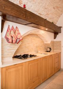 eine Küche mit Herd und Ziegelwand in der Unterkunft Casa del Carbonaio in Locorotondo