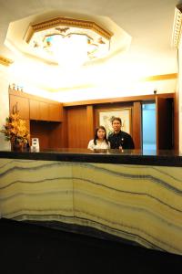 um homem e uma mulher de pé numa casa de banho em Wirton Hotel em Bandung