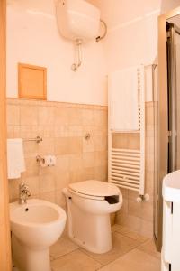 ein Badezimmer mit einem weißen WC und einem Waschbecken in der Unterkunft Casa del Carbonaio in Locorotondo
