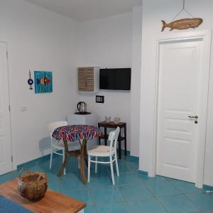 a dining room with a table and chairs and a television at La Casa Di Massimiliano - Villa del Sole in Capri