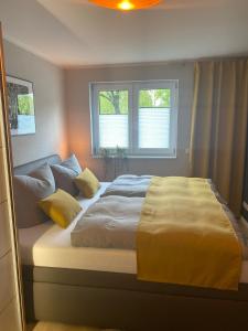 - un grand lit dans une chambre avec 2 fenêtres dans l'établissement Spree Chalet Cottbus, à Cottbus